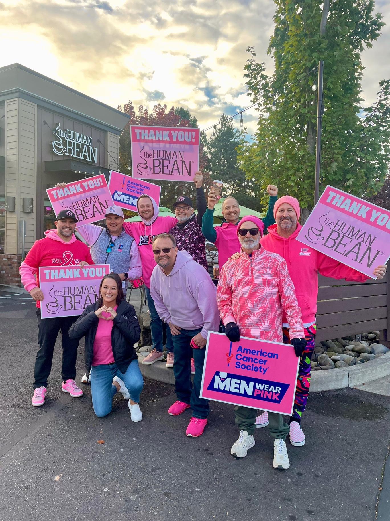 Men Wear Pink ambassadors holding thank-you signs at The Human Bean coffee stand